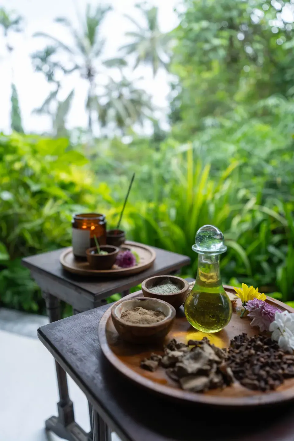 Herbal powders, dried herbs and oil on a tray in the garden