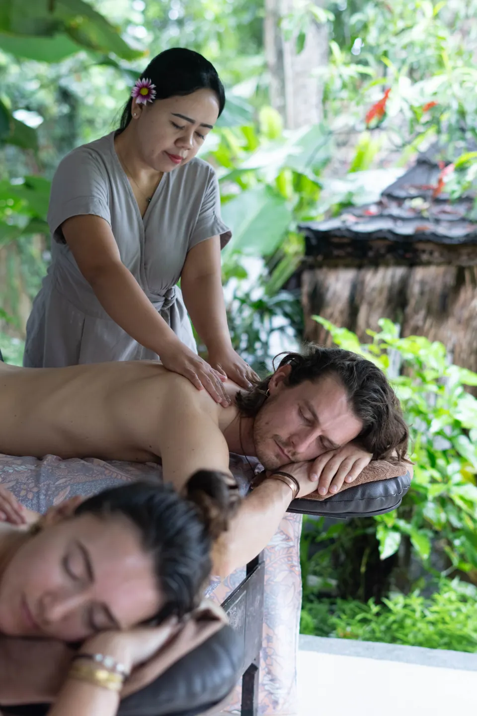 A therapist massaging two guests in the spa pavilion