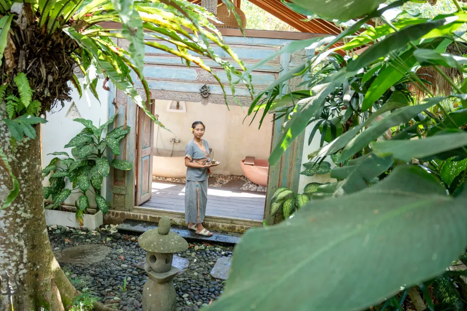 A member of the spa team beside the garden path and bath room doors