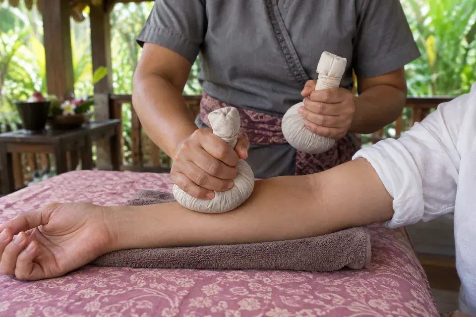 Cotton herbal boluses applied to the forearm