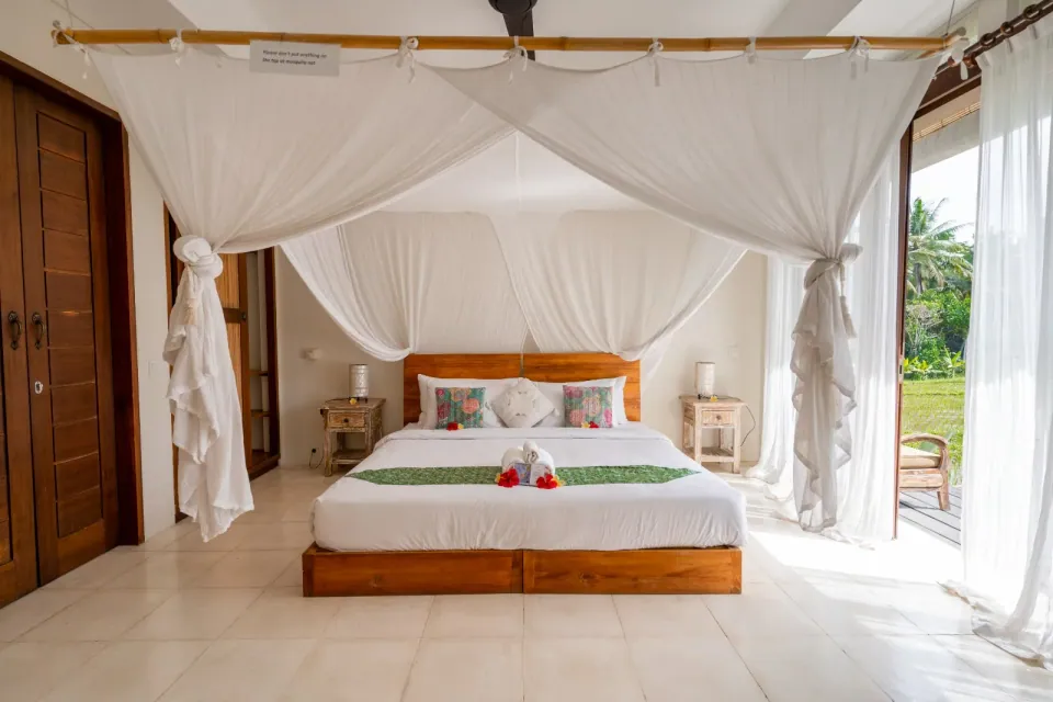 A light-filled canopy bedroom opening toward the garden
